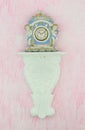 Vintage porcelain clock against a pink background Royalty Free Stock Photo