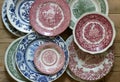 Vintage porcelain plates in different sizes and colors on a wooden background. Rustic style.