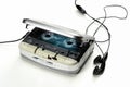 Vintage portable audio tape compact cassette player with headphones and cassette, gray device on white background Royalty Free Stock Photo