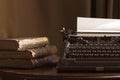 Vintage portable typewriter with a piece of paper and vintage bo Royalty Free Stock Photo