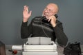 Vintage portrait. The author journalist laughs. Table with telephone and typewriter. Writer editor Royalty Free Stock Photo