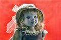 Vintage portrait of beautiful retro porcelain doll wears a headdress with blond curly hairs and blue eyes a retro toy as  old- Royalty Free Stock Photo