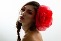 Vintage portrait of fashion glamour girl with red flower in her hair, studio shot. Royalty Free Stock Photo