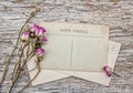 Vintage postcard and dry tea roses on the old wood Royalty Free Stock Photo