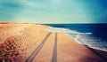 Vintage processed photo of long evening shadows on the beach at Royalty Free Stock Photo