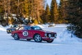 Vintage racing cars driving classic rally on snow covert road Royalty Free Stock Photo