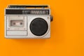 Vintage radio and cassette player on colour background