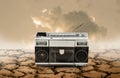 Vintage radio and cassette player on cracked earth, Technology in wilderness