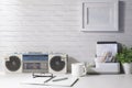 Vintage radio, coffee cup, notebook and potted plant on white table with daylight from the window. Copy space for advertise text