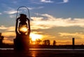 Vintage Railroad Lantern Lights Up sunset on water Royalty Free Stock Photo