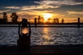 Vintage Railroad Lantern Lights Up sunset on water Royalty Free Stock Photo