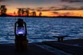 Vintage Railroad Lantern Lights Up sunset on water