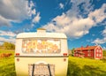 Vintage rear of a caravan in front of a typical old wooden farm house in Smaland, Sweden Royalty Free Stock Photo