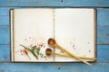 Vintage cookbook with empty pages, spices and wooden spoons