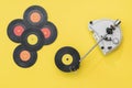 Vintage record player and multi-colored vinyl discs on a yellow background. Royalty Free Stock Photo