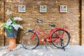 Vintage red bicycle against sandstone brick wall with decoration Royalty Free Stock Photo