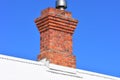 Red brick chimney on white roof Royalty Free Stock Photo