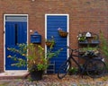 Vintage red bricks House faÃÂ§ade with blue doors and flowers