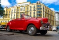 Vintage red Ford parked near a hotel in Havana