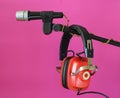 Vintage red headphone and old microphone on pink background, podcast,recording sound,vinatge audio gear concept. Free copy space Royalty Free Stock Photo