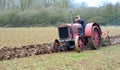 Vintage red International 1930`s tractor ploughing field. Royalty Free Stock Photo