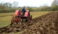 Vintage red International 1930`s tractor ploughing field. Royalty Free Stock Photo