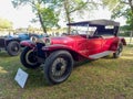 Vintage red 1926 Lancia Lambda VII Series Torpedo in a park.