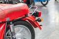 Vintage red motorcycle, stationary in indoor setting Large storage compartment attached to back Side angle view with tilted front Royalty Free Stock Photo