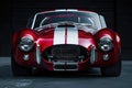 Classic Red and White Muscle Car Poised in a Dark Studio Setting Royalty Free Stock Photo