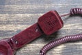 Vintage red old telephone receiver with cord on a wooden board Royalty Free Stock Photo