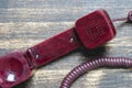 Vintage red old telephone receiver with cord on a wooden board Royalty Free Stock Photo