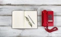 Vintage red phone and notepad with pen and reading glasses on ru Royalty Free Stock Photo