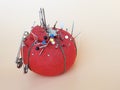 Vintage red pincushion with safety pins, needles and thread