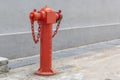 Vintage red street fire hydrant on a gray wall background. Royalty Free Stock Photo