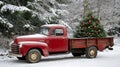 A vintage red truck with a Christmas tree in the back Royalty Free Stock Photo
