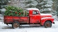 A vintage red truck with a Christmas tree in the back Royalty Free Stock Photo
