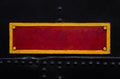 Vintage red and yellow metal plate on the old train. Textured background. Close shot.