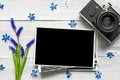 Vintage retro camera, blank photo frame and spring blue flowers