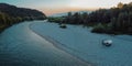 Vintage retro campervan parked on the wild camping ground next to a river at late hazy evening hours. Adventure campers taking a Royalty Free Stock Photo