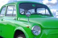 Vintage retro car. small soviet retro car of green color against the sky with clouds