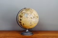 Vintage retro classic school globe model of Earth on wood floor grey background Royalty Free Stock Photo