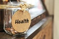 Vintage retro glass jar with hemp rope tie health tag and few coins inside on wood counter concept of save money for health care m Royalty Free Stock Photo