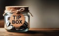 Vintage retro glass jar with hemp rope tie tip box tag and few coins inside on wood counter Royalty Free Stock Photo