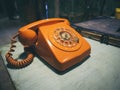 Vintage Retro phone orange color on table Royalty Free Stock Photo