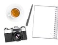 Vintage retro photo camera, coffee cup, notepad and pen isolated on white background. Flat lay. Royalty Free Stock Photo