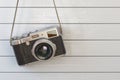 Vintage retro photo camera hanging on the white wooden wall. Royalty Free Stock Photo