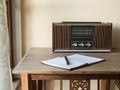 Vintage retro radio, notebook and pen on wooden table Royalty Free Stock Photo