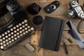 Vintage retro typewriter, analog film camera and notebook on brown wooden table background top view flat lay from above - Royalty Free Stock Photo