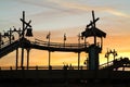 Retro log flume ride set against orange sunset sky Royalty Free Stock Photo