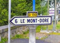 A vintage road sign indicates the direction of the town of Le Mont-Dore, located in central